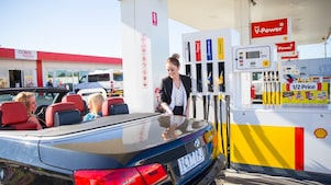 Woman refueling her car at a Shell Coles Express station