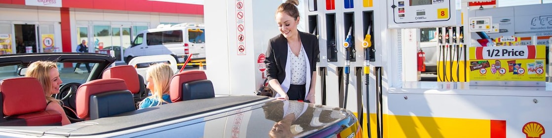 Woman refueling her car at a Shell Coles Express station
