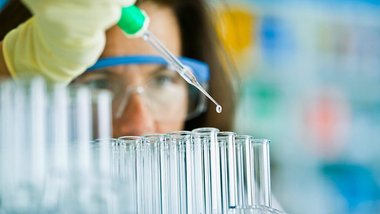 lab technician pipette liquid into test tubes