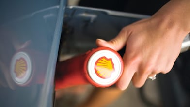 Hand holding a Shell pump nozzle