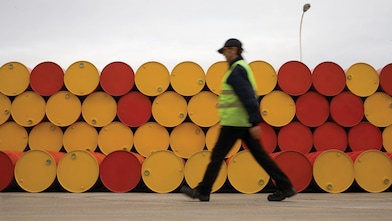 Man walking past barrels of Lubricants
