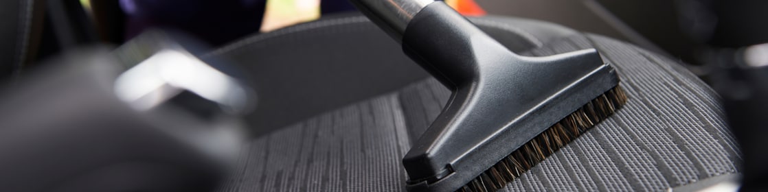 person vacuuming the car seat