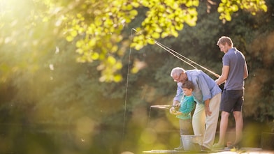 Grandpa, son and grandson fishing by the lake