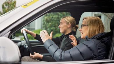 Mother guiding daughter how to drive