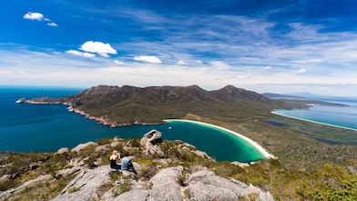A couple take in the view of Wineglass Bay from a lookout in Freycinet National Park