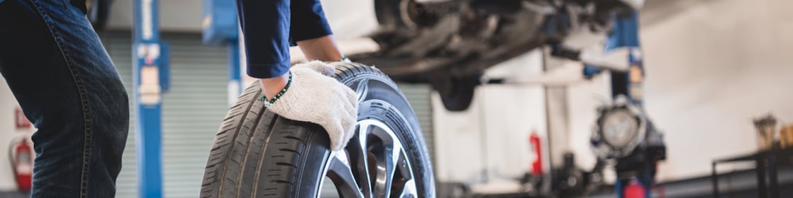 Mechanic wheeling a tyre