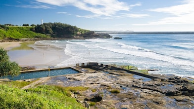 Seaside pool at Yamba beach, with lighthouse in the distance