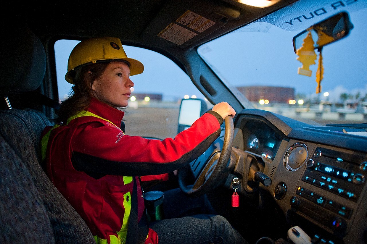 A lady wearing safety equipment driving a vehicle
