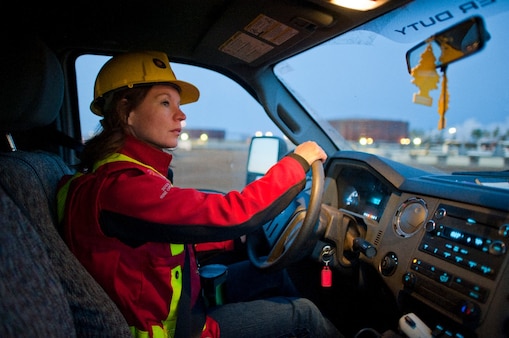 A lady wearing safety equipment driving a vehicle