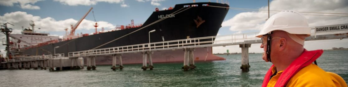 Jetty worker manning response vessel next to tanker